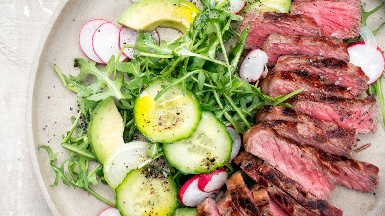 Plate of sliced skirt steak with salad