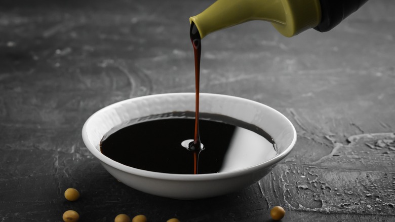 Soy sauce poured into ramekin with soybeans