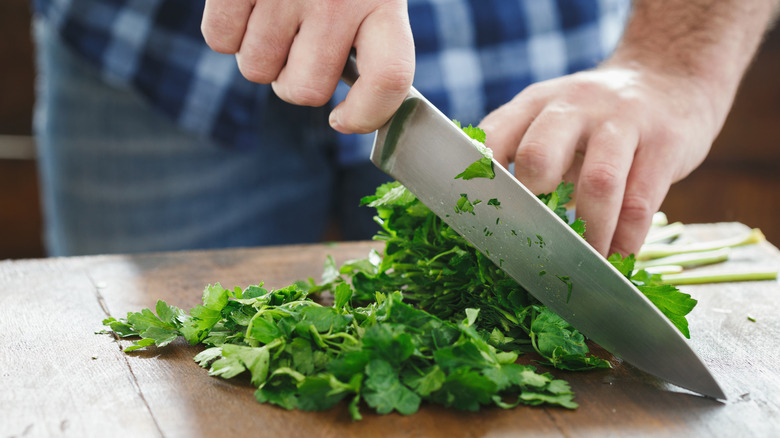 person chopping fresh herbs