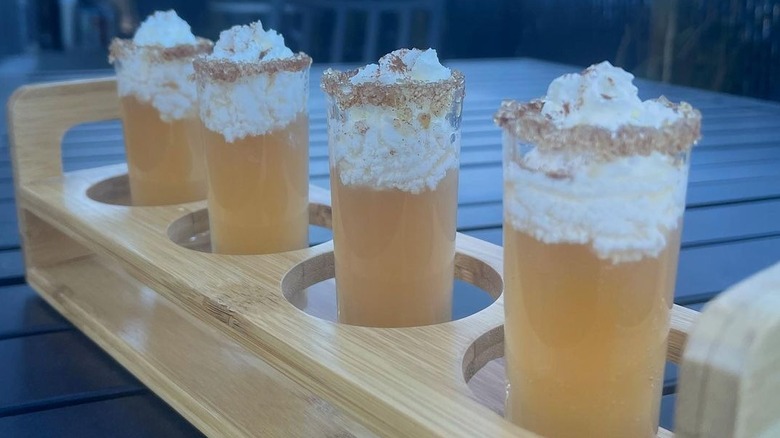 Apple pie shots with whipped cream and cinnamon rim