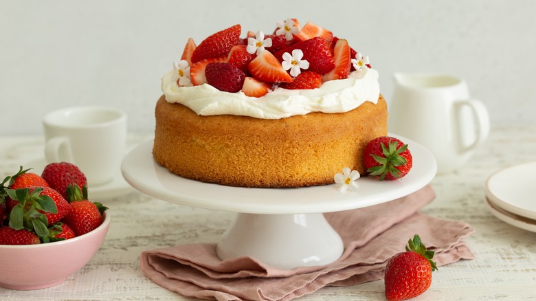 A cake stand holding a strawberry cake