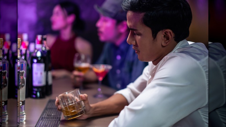 Depressed man staring at his drink