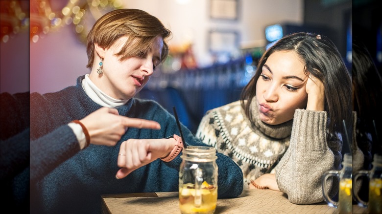 woman looks annoyed by conversation in a bar