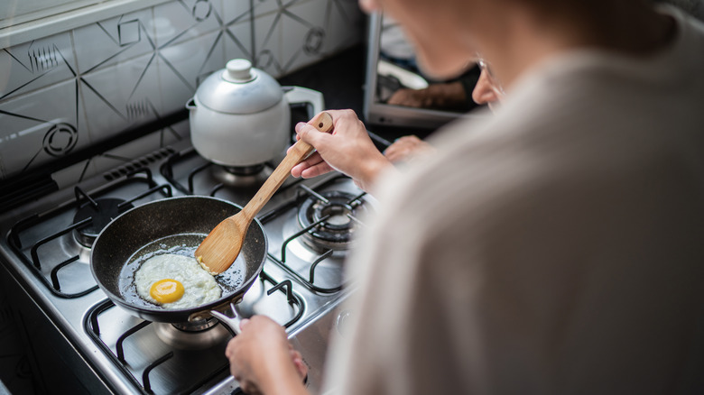 Woman frying an egg