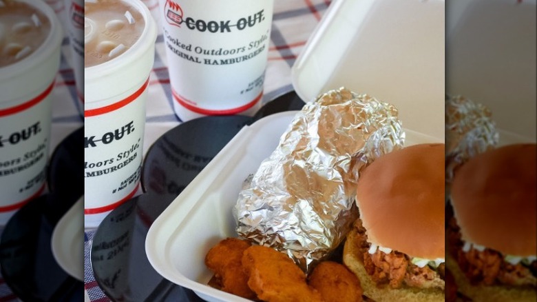 Styrofoam box with Cook Out milkshakes and burger