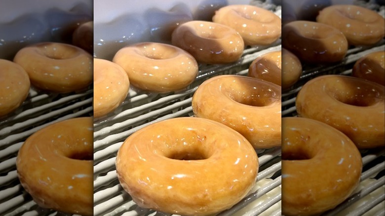 Donuts lined up on conveyor belt