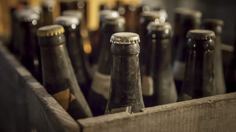 dusty old beer bottles in crate