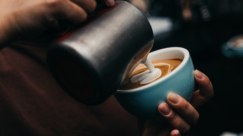 Pouring cup of frothed milk