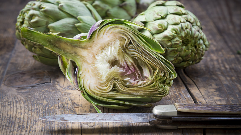 raw artichokes on cutting board