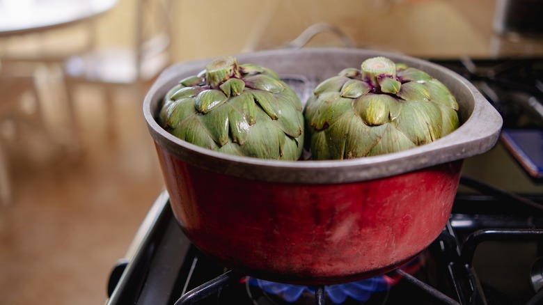 artichokes steaming in red pot