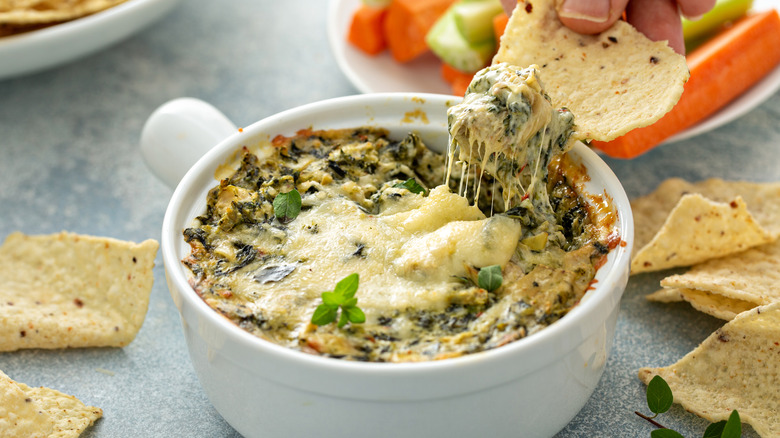 scooping spinach artichoke dip