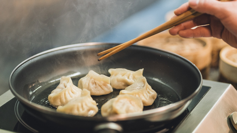 Pan-frying dumplings with chopsticks