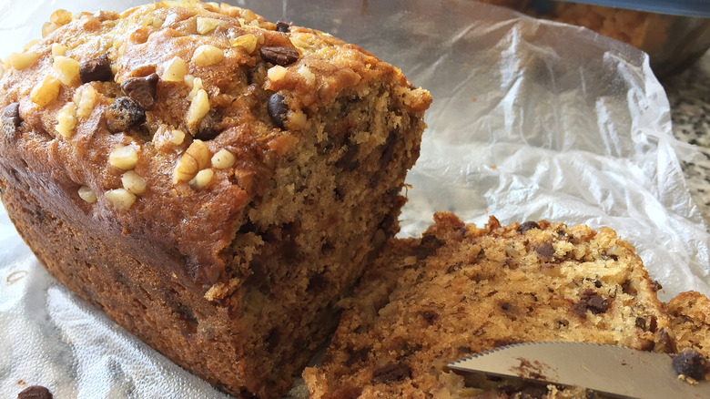 a loaf of banana bread on piece of plastic wrap