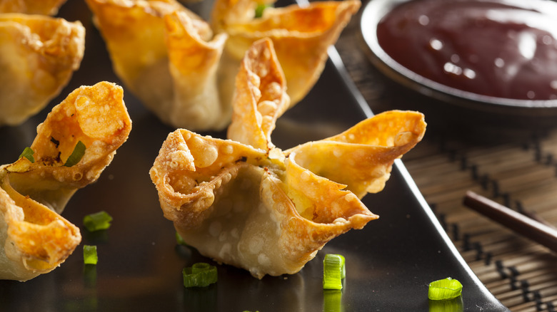 Crab rangoon on black plate