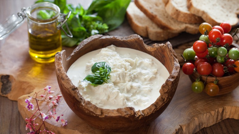 bowl of stracciatella cheese, board