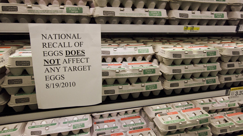 Rows of egg cartons displayed during the 2010 egg recall, with paper sign that reads "NATIONAL RECALL OF EGGS DOES NOT AFFECT ANY TARGET EGGS 8/19/2010"