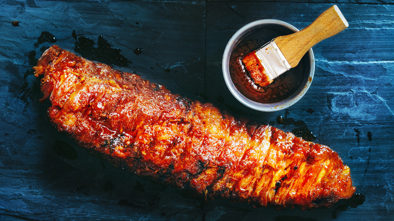 Ribs being glazed with barbecue sauce