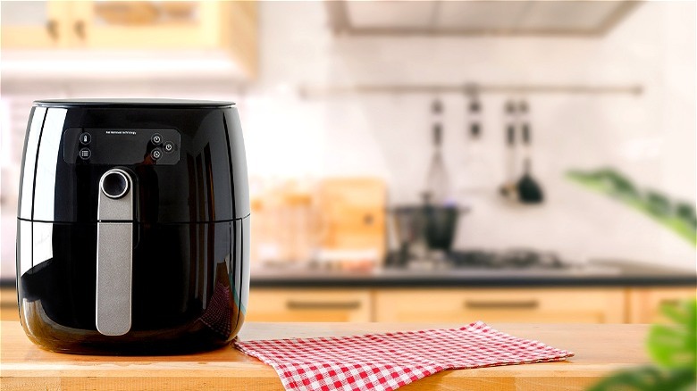 Black air fryer on wooden counter