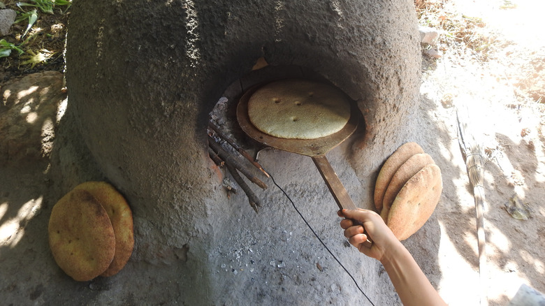 baking flatbread in earth oven