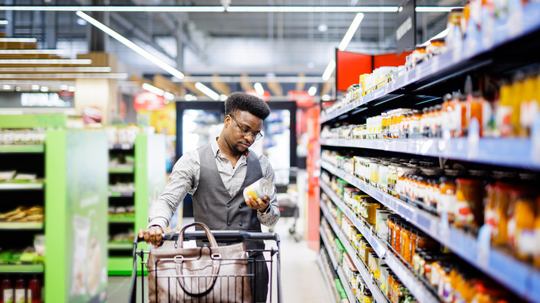 Person reading label on canned food