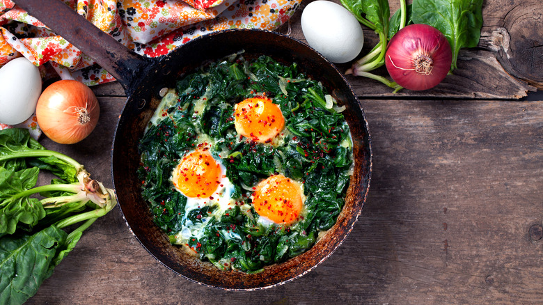 braised spinach and eggs in a skillet