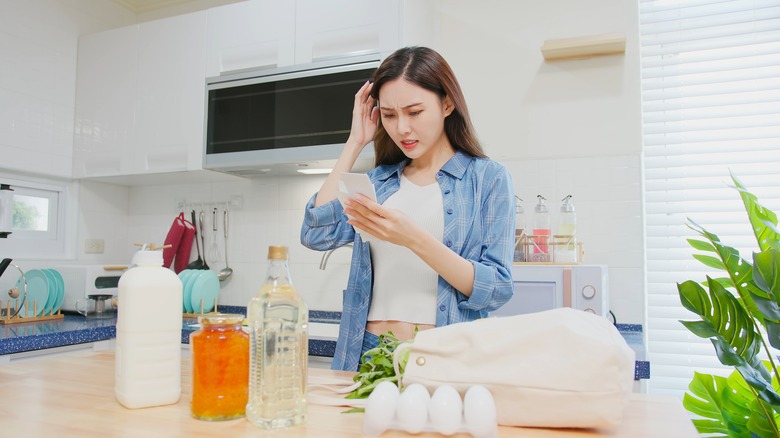 woman reading grocery receipt