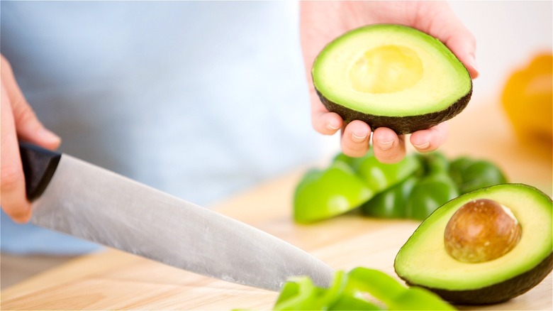 Hand holding half an avocado