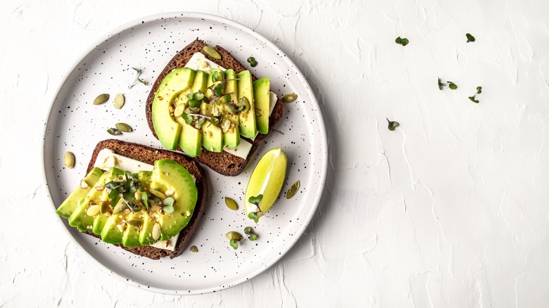 Plated avocado slices on rye toast