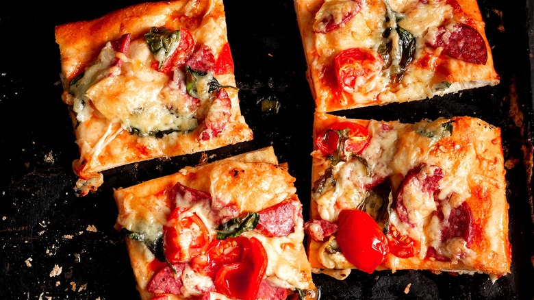 Square pizza slices on baking sheet 
