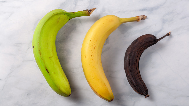 Green, yellow, and brown bananas