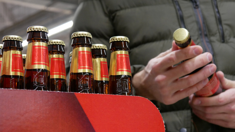 Person checking label on beer bottle