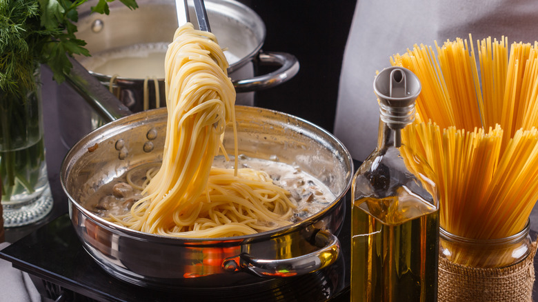 Adding spaghetti to sauce pan