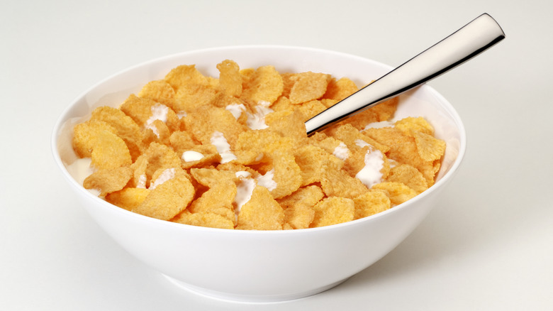 Corn flakes with milk in white bowl