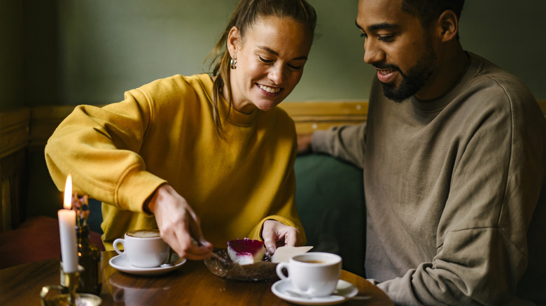 A couple sharing a dessert at a candle-lit table