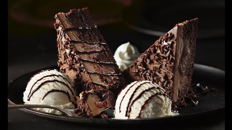 Chocolate Stampede with ice cream, whipped cream on a plate with a fork ready for a bite