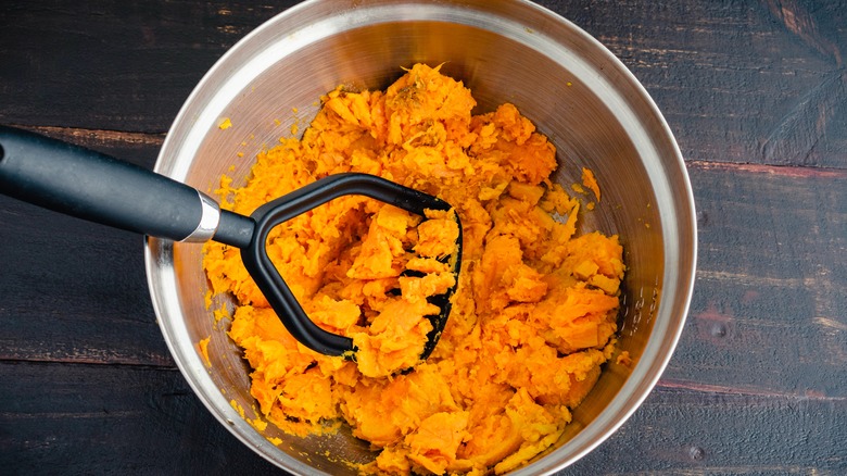mashing sweet potatoes in bowl
