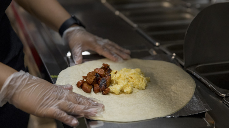 worker making a breakfast burrito