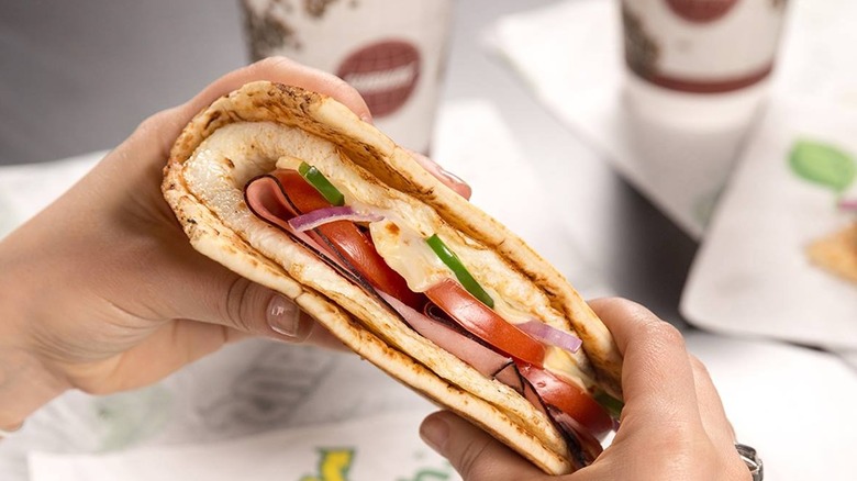 woman holding breakfast sandwich