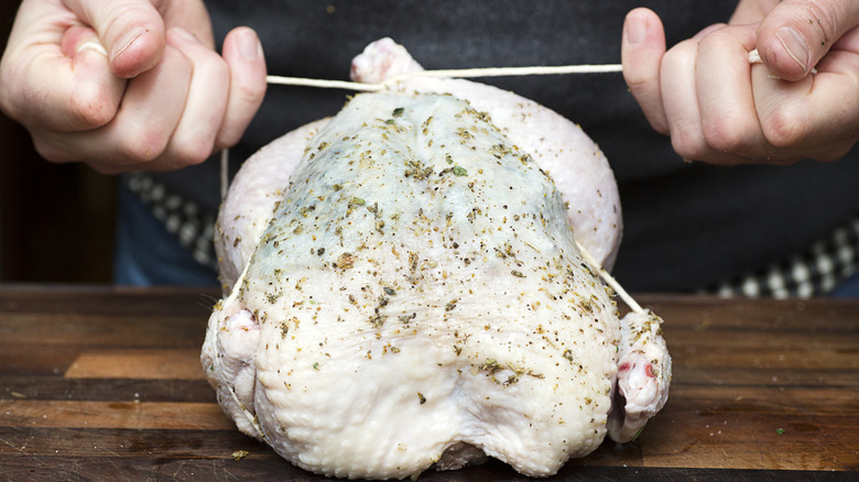 Cook trussing a chicken