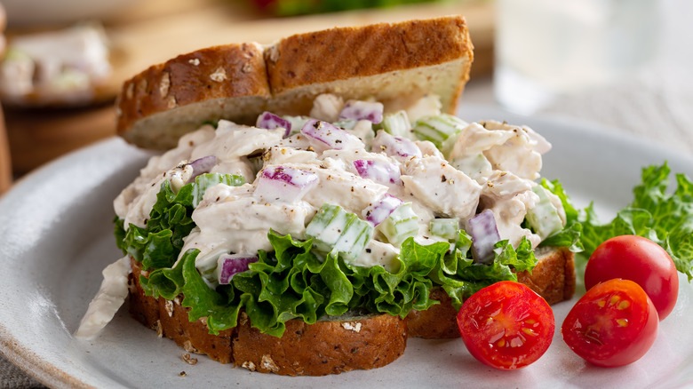 Chicken salad sandwich on plate with tomatoes