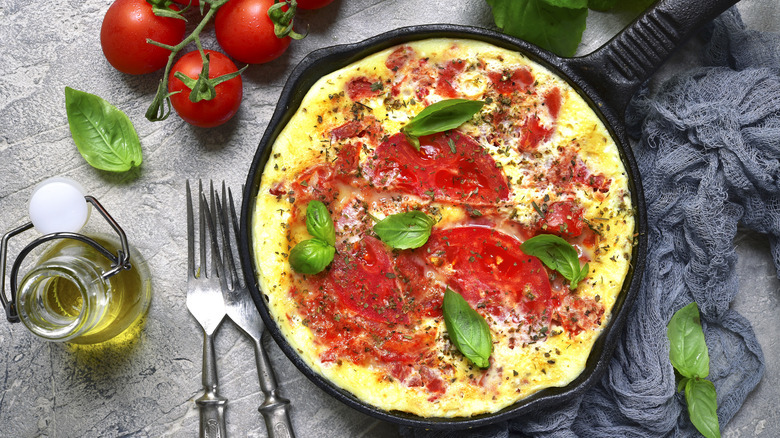 Omelet with tomatoes in a cast iron pan