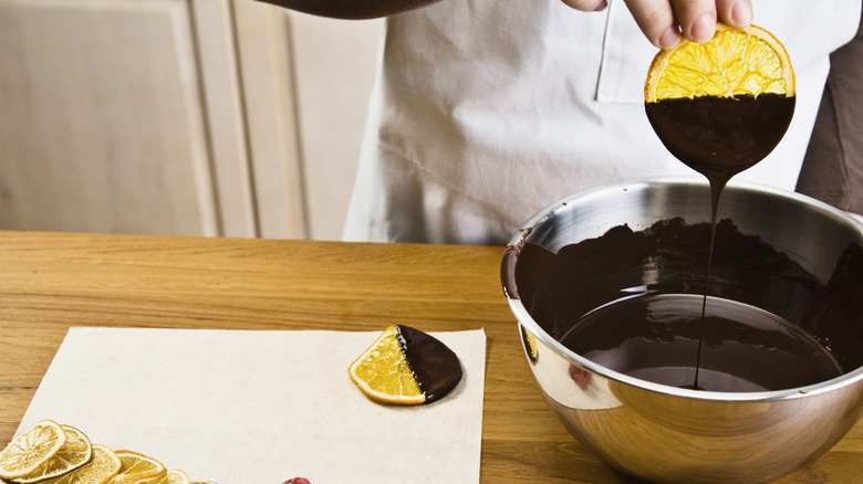 Dipping fruit into candy