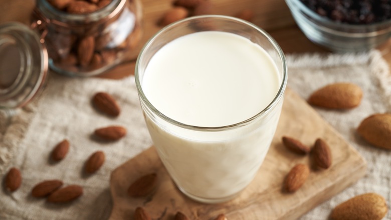 Milk glass surrounded by almonds