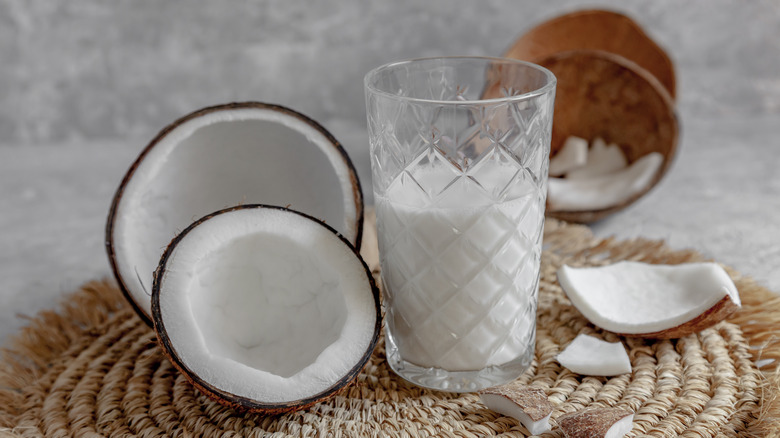 Milk glass besides coconut halves