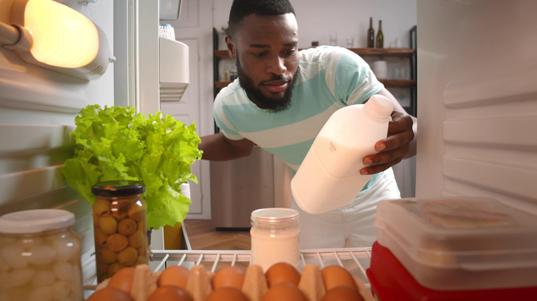 Person taking milk from refrigerator