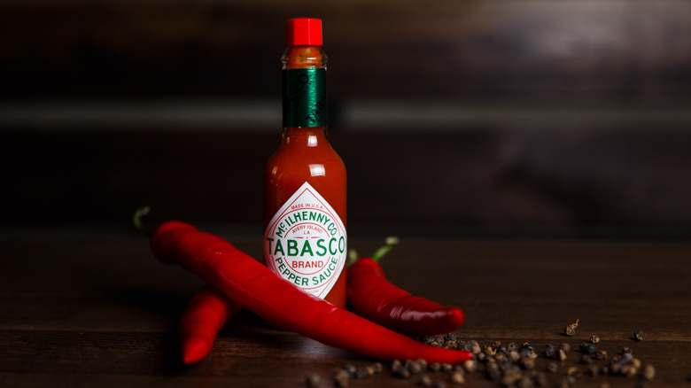 A bottle of Tabasco sauce on a wooden table 