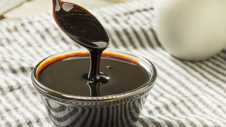 Spoon dipping into bowl of molasses