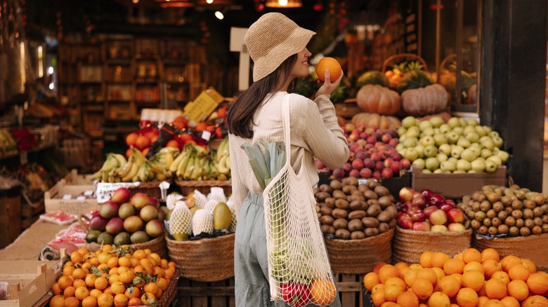 Person inspecting tangerines at store