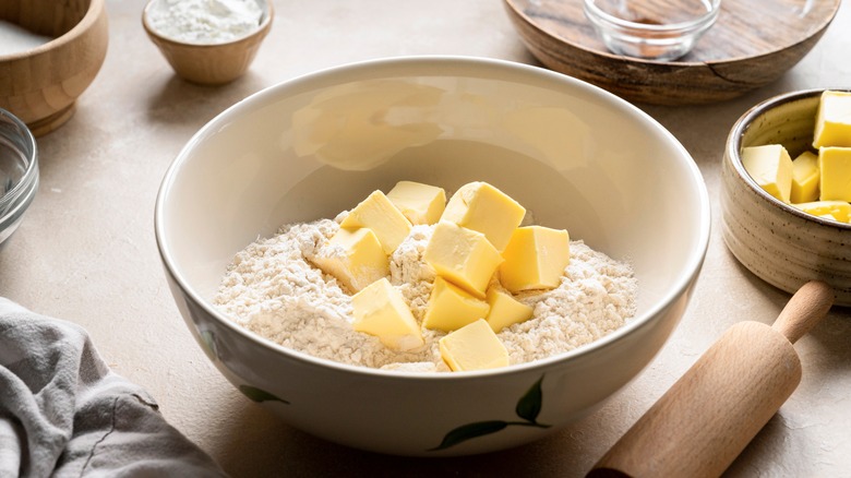 pieces of butter in bowl with flour