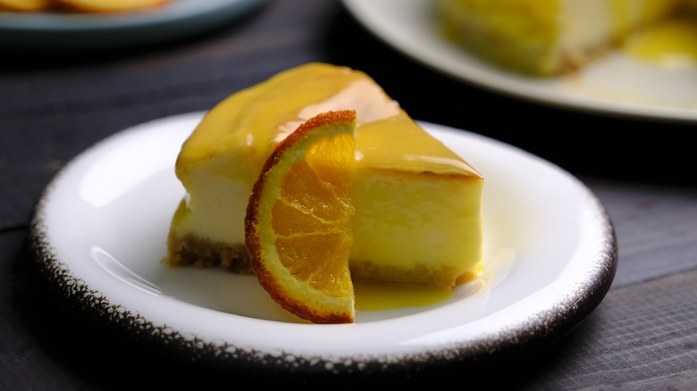 A slice of cheesecake adorned with candied orange slice